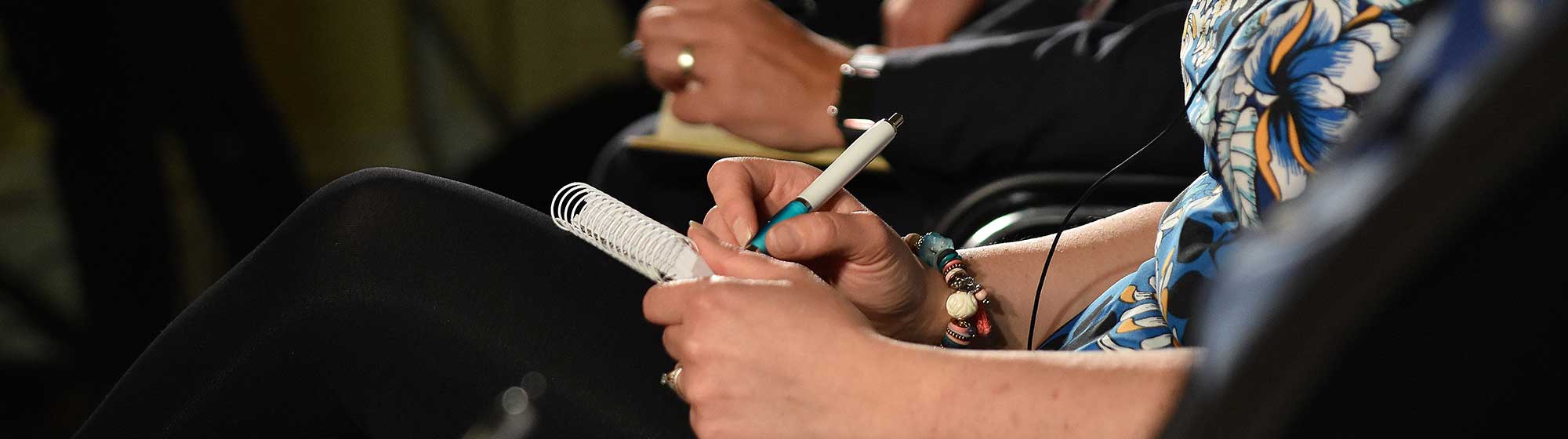 Journalistes prenant des notes lors d'une conférence de presse