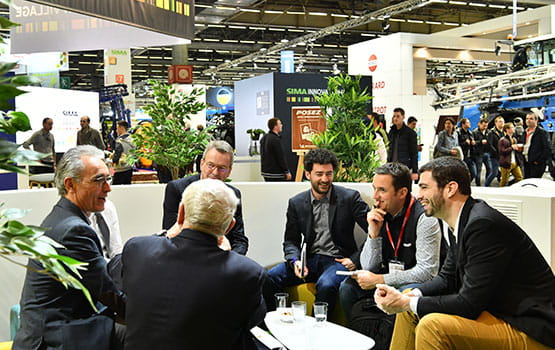 Several men sitting and talking in front of the Innovation Village